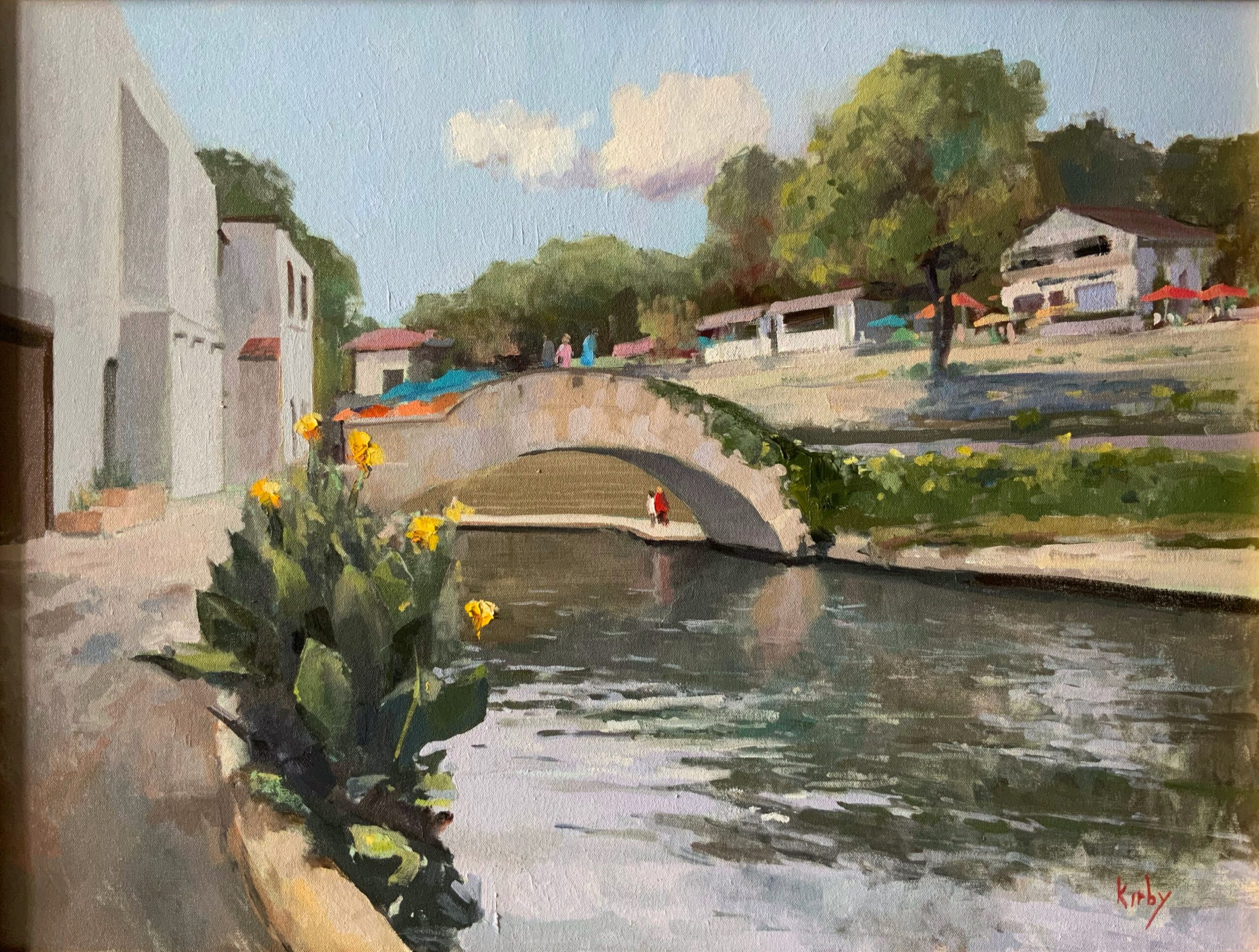 An oil painting, titled Touring the Rive Walk, by artist Randall Cogburn, illustrates a serene painting of the San Antonio River walk with tourists st anding at the crest of one of the many crossing bridges